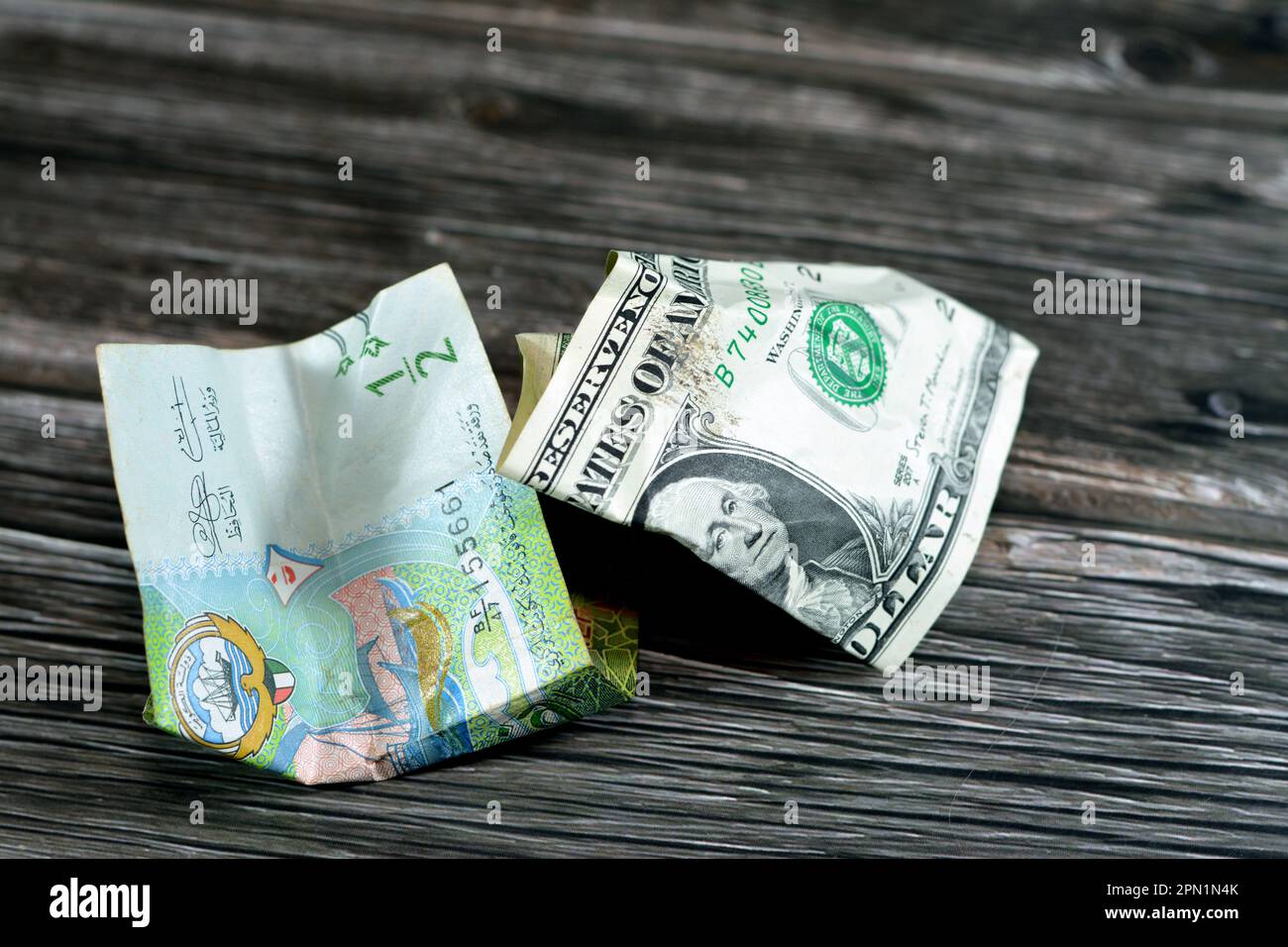 Zerknitterte und zerknitterte kuwaitische halbe KWD-Dinar-Banknote und 1 US-Dollar Bargeld, Geldinflation und Wertverlust, Drop Concept, Busin Stockfoto