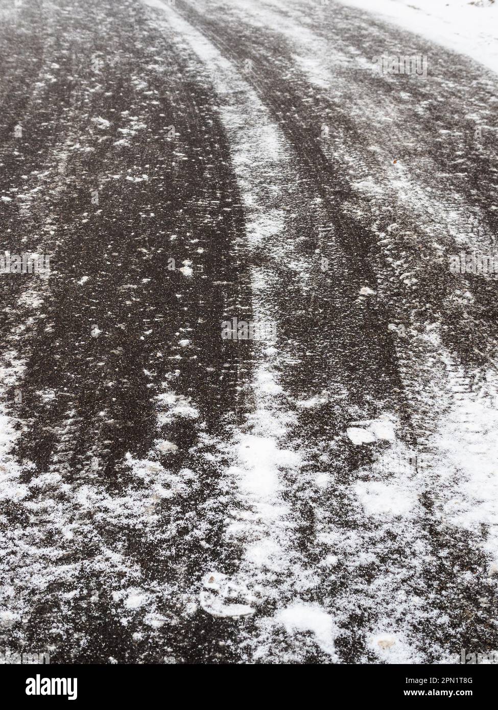 Vereiste Oberfläche der Asphaltstraße an bewölktem Wintertag Stockfoto