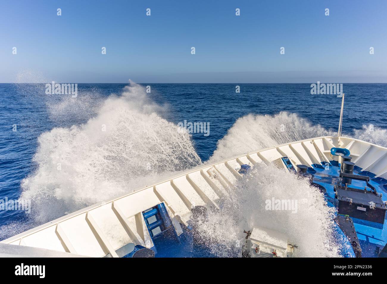 Erleben Sie das Abenteuer auf dem offenen Meer! An Bord eines Kreuzfahrtschiffs spritzt die Gicht durch die Welle in die Luft. Ein unvergessliches Erlebnis! Stockfoto
