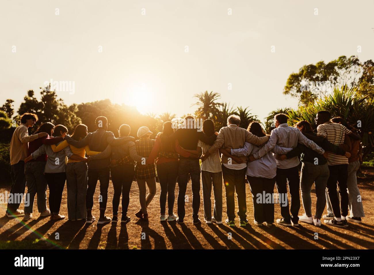 Rückblick auf glückliche, generationsübergreifende Menschen, die während des Sonnenuntergangs in einem öffentlichen Park Spaß haben - Community- und Support-Konzept Stockfoto