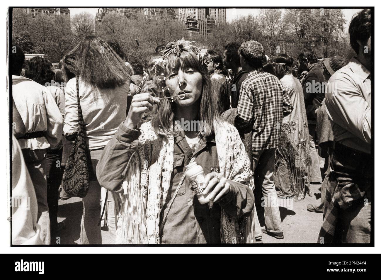 Der Geist der 1960er in der Mitte der 1970er Jahre. Eine attraktive junge Dame bläst bei einer Kundgebung im Washington Square Park um 1974 herum Blasen. Stockfoto