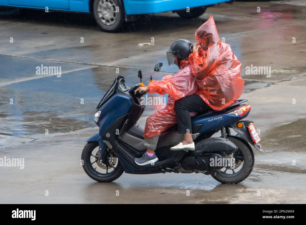 Ein Paar fährt im Regen Motorrad, Thailand Stockfoto