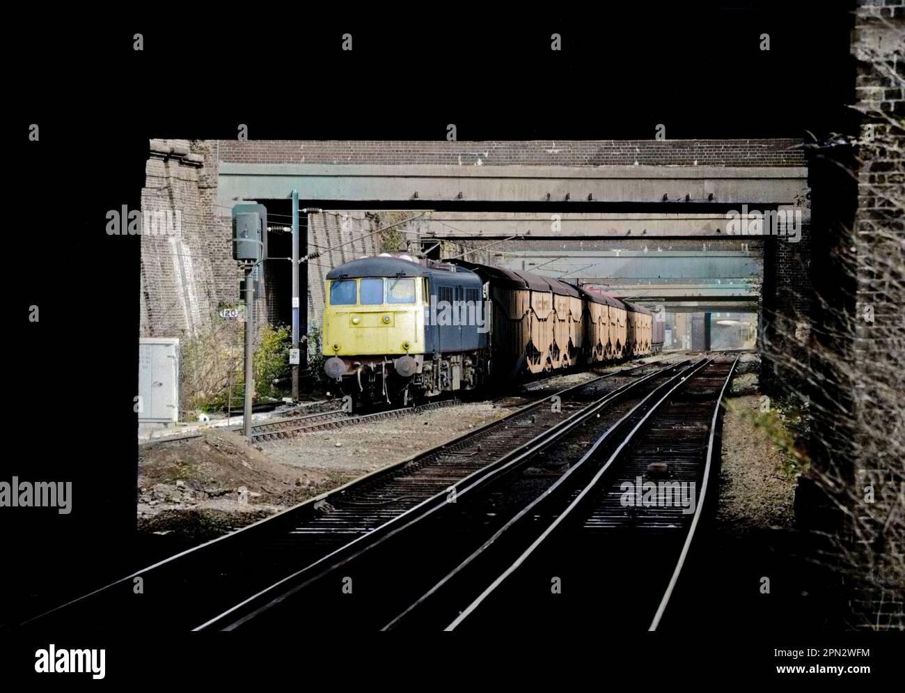 Eine elektrische Lokomotive der Baureihe 85 mit der Nummer 85108, die einen beladenen Autotransporterzug aus Silcock Cartic-4 fährt, fährt am 14. März 1991 auf der North London Line auf die Caledonian Road und Barnsbury. Stockfoto