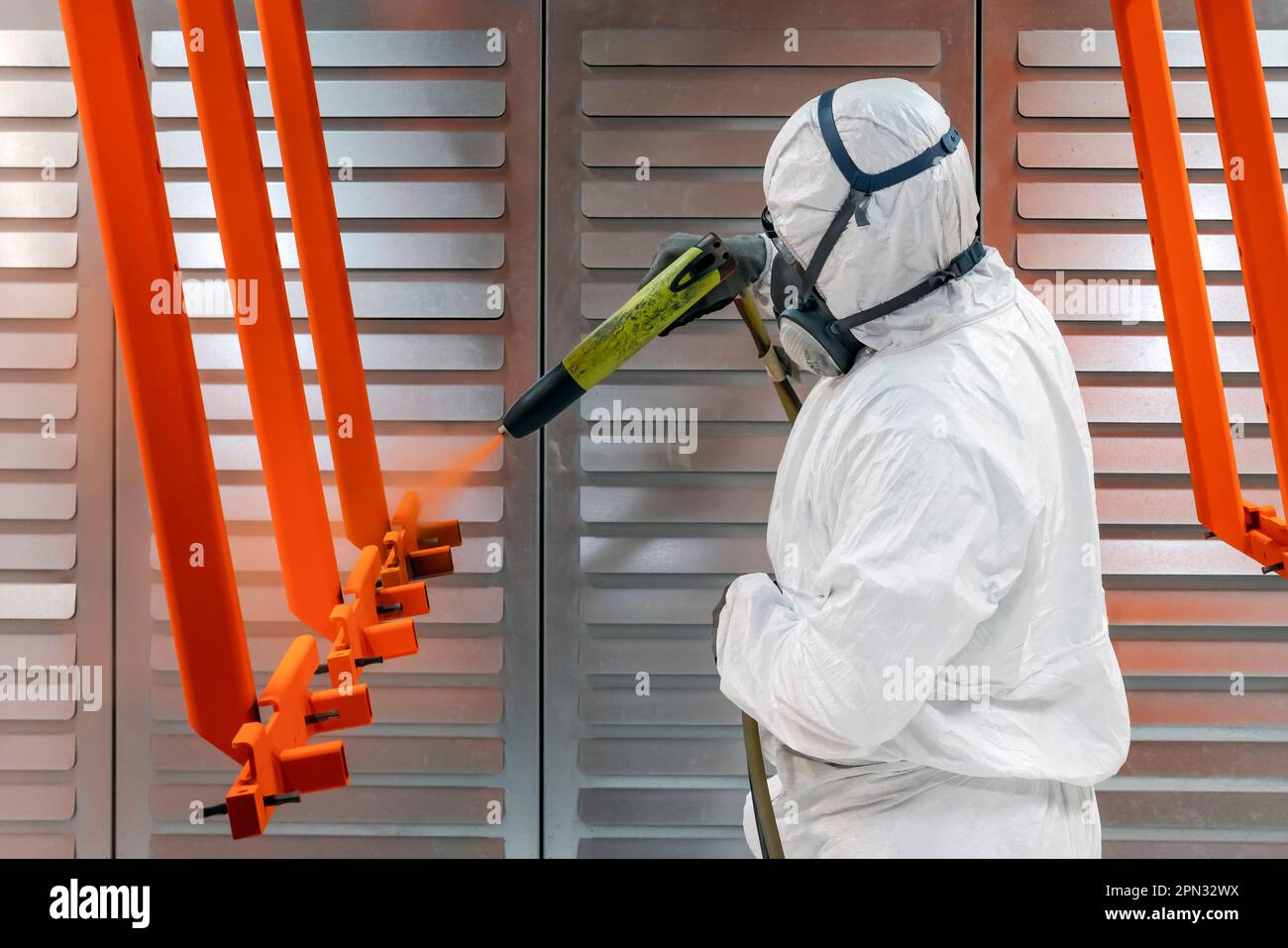 Arbeiter, der mit einer Lackierpistole in einer Fabrik in Frankreich malt Stockfoto
