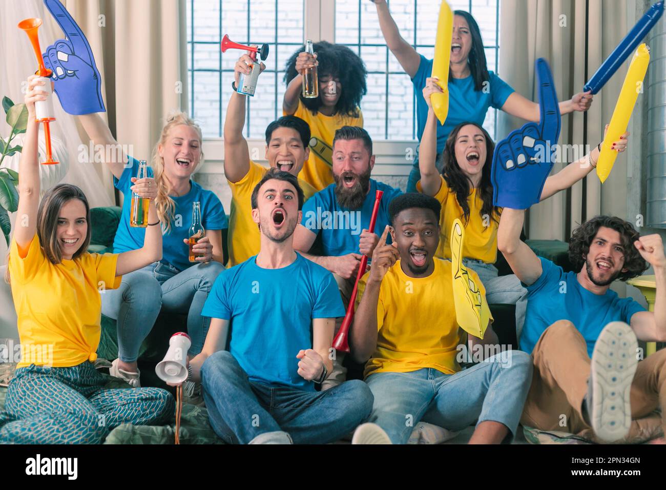 Ziel. Sehr aufgeregte Freunde, die Spaß dabei haben, sich ein Fußballspiel anzusehen und zu Hause zu essen, drinnen. Freundschaft, Vergnügen, Ruhe, Heim-Party-Konzept Stockfoto