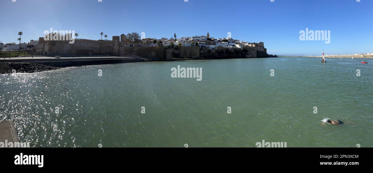 Marokko: Rabat, Skyline der alten Kasbah der Udayas, die Zitadelle, die im 12. Jahrhundert von den Almohads mit einem Jungen erbaut wurde, der im Bou Regreg-Fluss schwimmt Stockfoto