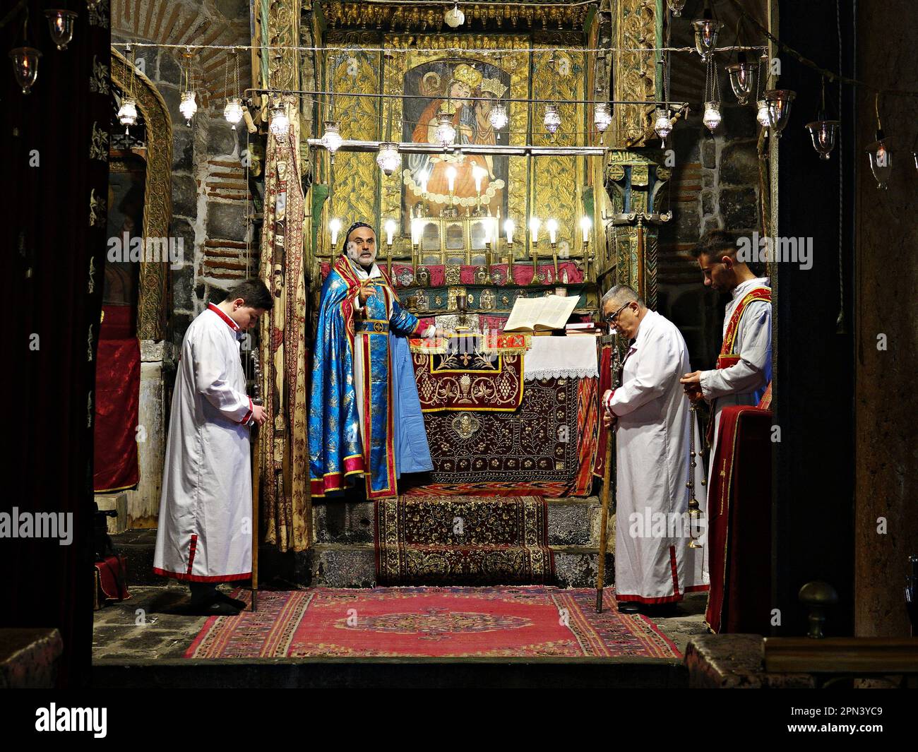 Priester Behnam Konutgan leitet die Messe in der Jungfrauenkirche in Diyarbakir mit seinem stellvertretenden Geistlichen und zwei jungen Assyrern. Die letzten Assyrer von Diyarbakir, bestehend aus zwei Familien und insgesamt 12 Personen, feierten die Osterferien mit einer Messe in der Jungfrau-Maria-Kirche. Der Pfarrer Behnam Konutgan, der aus dem Kloster Mardin Deyrul Zaferan in Auftrag gegeben wurde, weil es in der Stadt keinen Geistlichen gab, der das Ritual durchführen konnte, führte die Regie. Eine kleine Anzahl Assyrer und ihre armenischen Freunde nahmen ebenfalls an der Messe Teil. Nach der Messe gab es speziell gebackene Brötchen und rote Eier Stockfoto