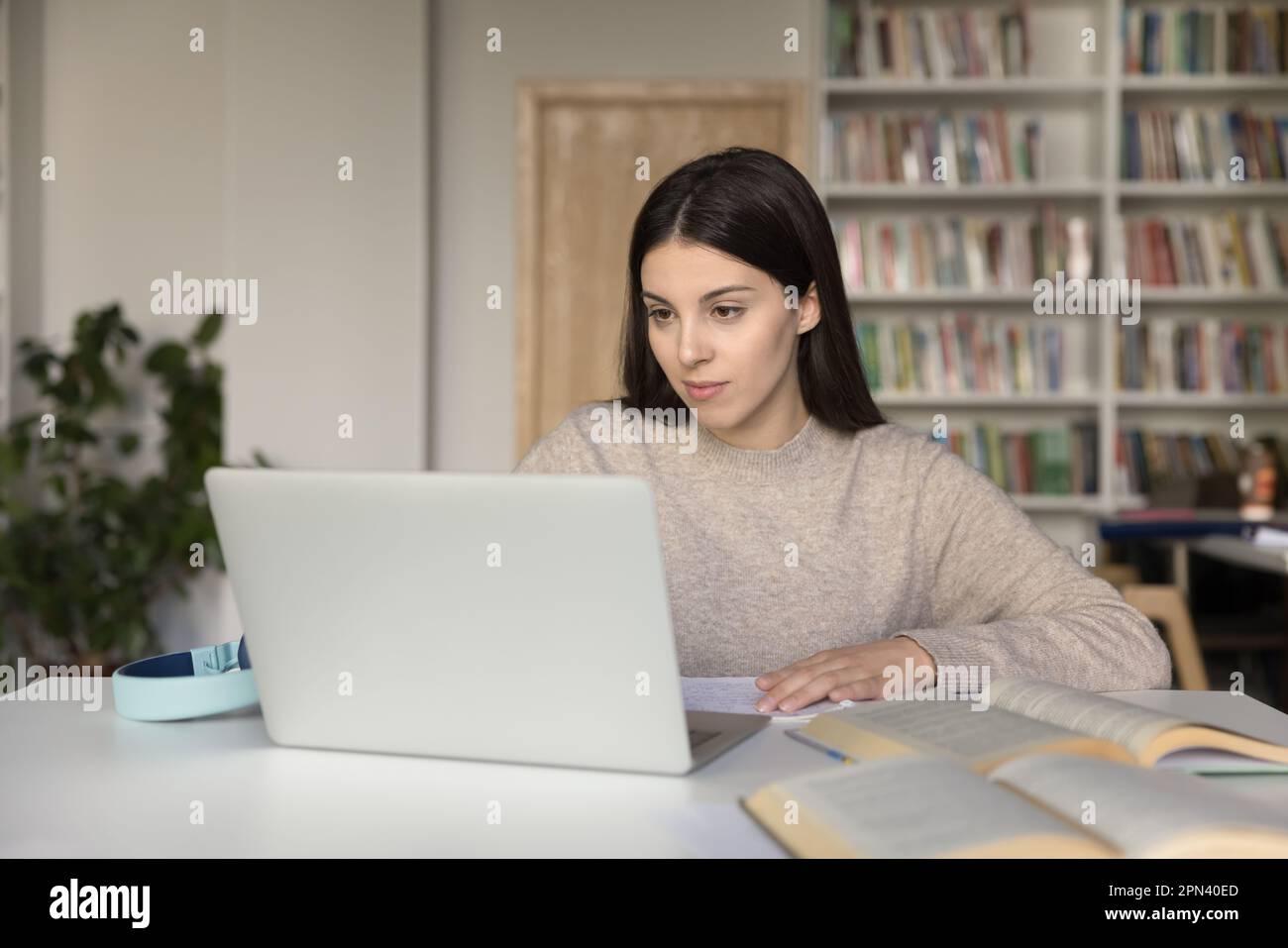 Attraktives Mädchen benutzt ein Notebook, das sich auf die Uni-Prüfungen vorbereitet Stockfoto