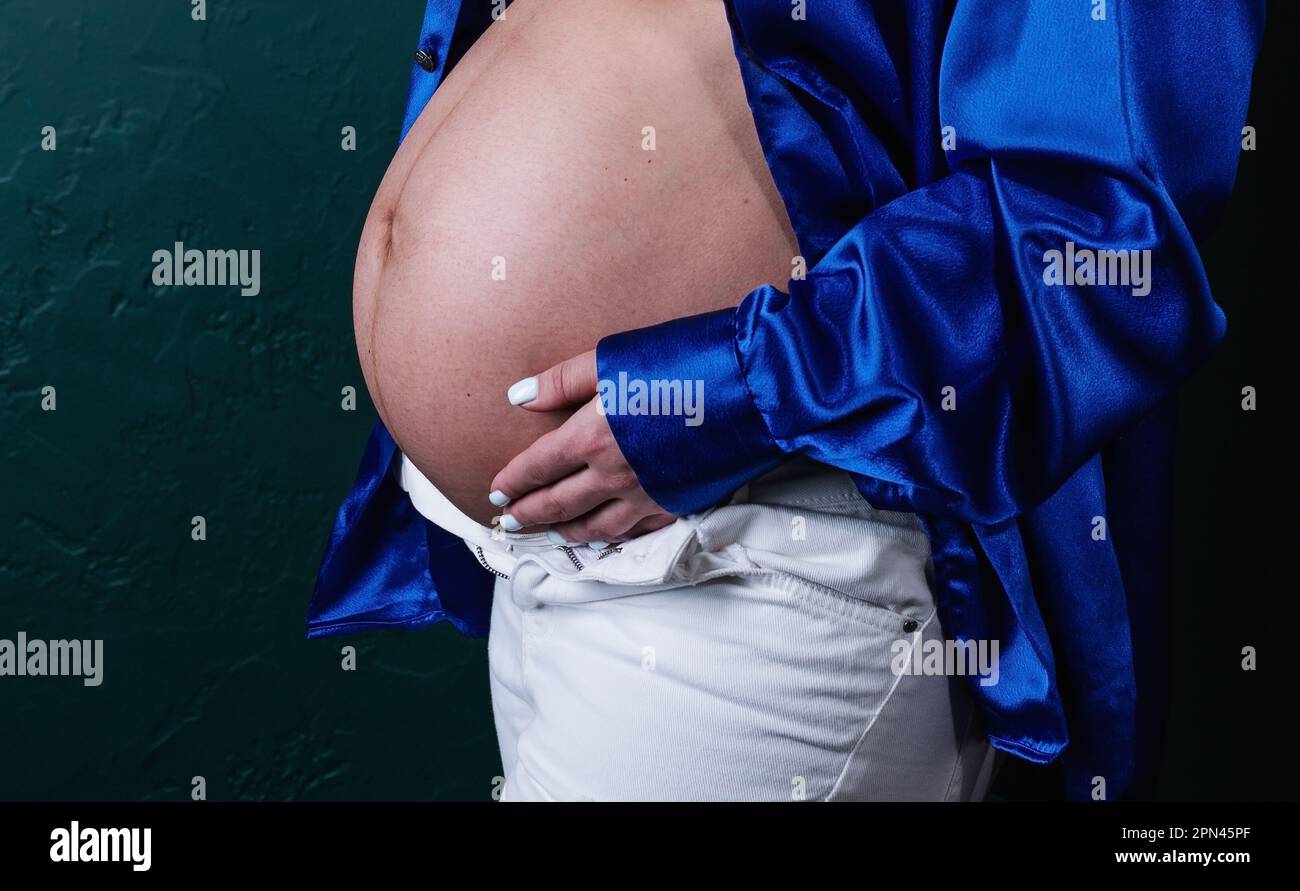 Porträt einer schwangeren Weißen, die ihre Hände an der Babybrücke hält. Stockfoto
