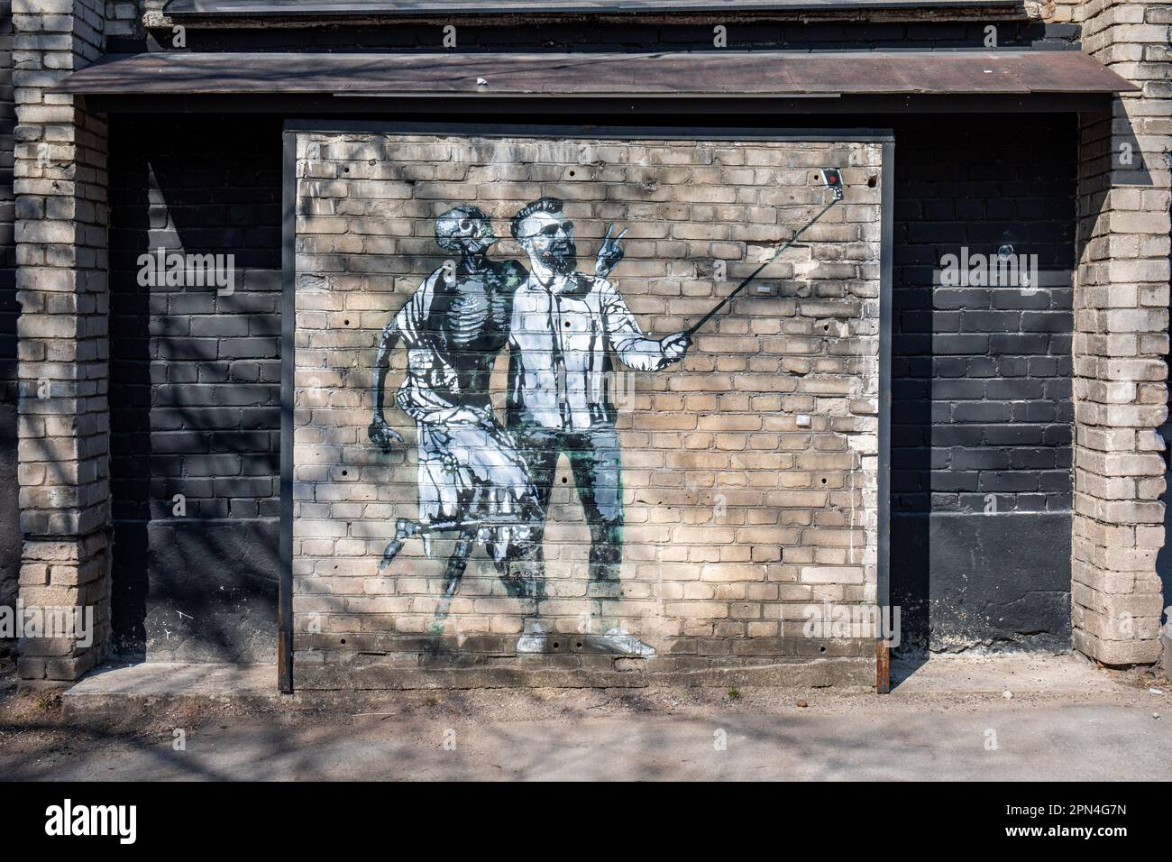 Tanz des Todes mit Endel oder Endel mit einem Stock (2017). Wandschablonen-Graffiti von Edward von Lõngus im Bezirk Telliskivi in Tallin, Estland. Stockfoto
