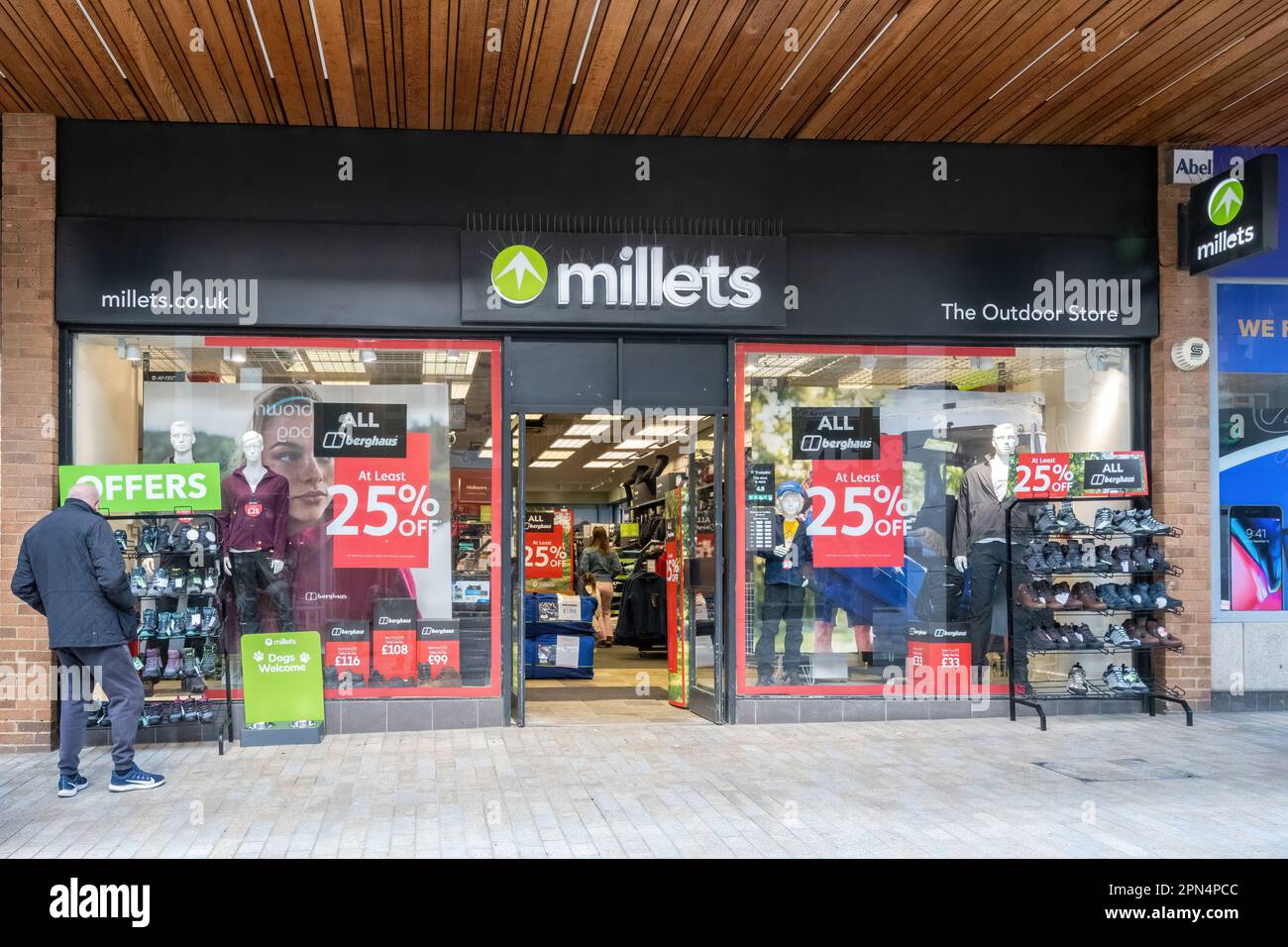 Ein Mann, der vor dem Millets Shop stöbert, ein Geschäft, das Outdoor-Kleidung verkauft, das Stadtzentrum von Bracknell, Berkshire, England, Großbritannien Stockfoto
