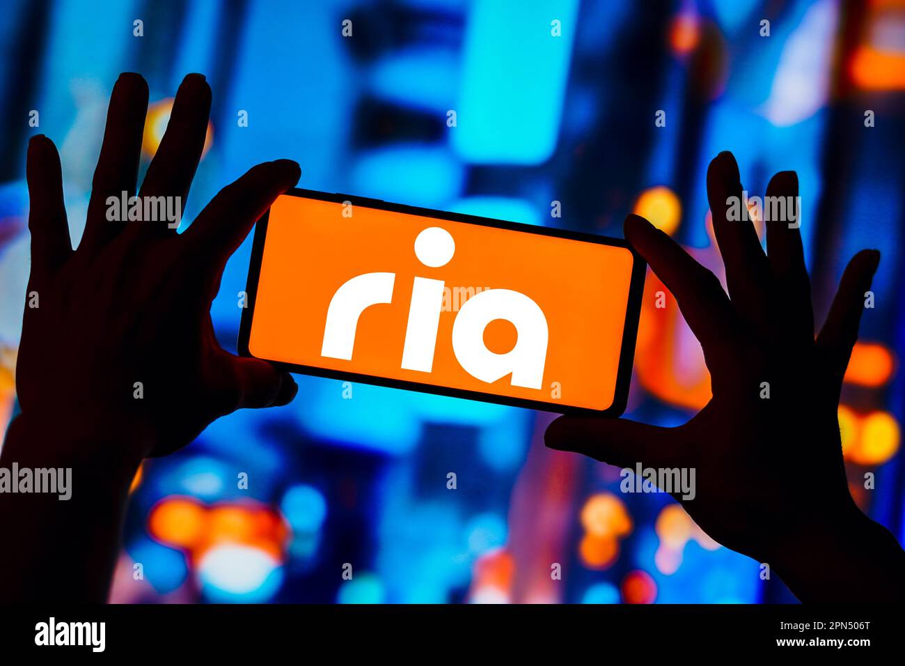 In dieser Abbildung wird das Ria Money Transfer Logo auf einem Smartphone-Bildschirm angezeigt. Stockfoto