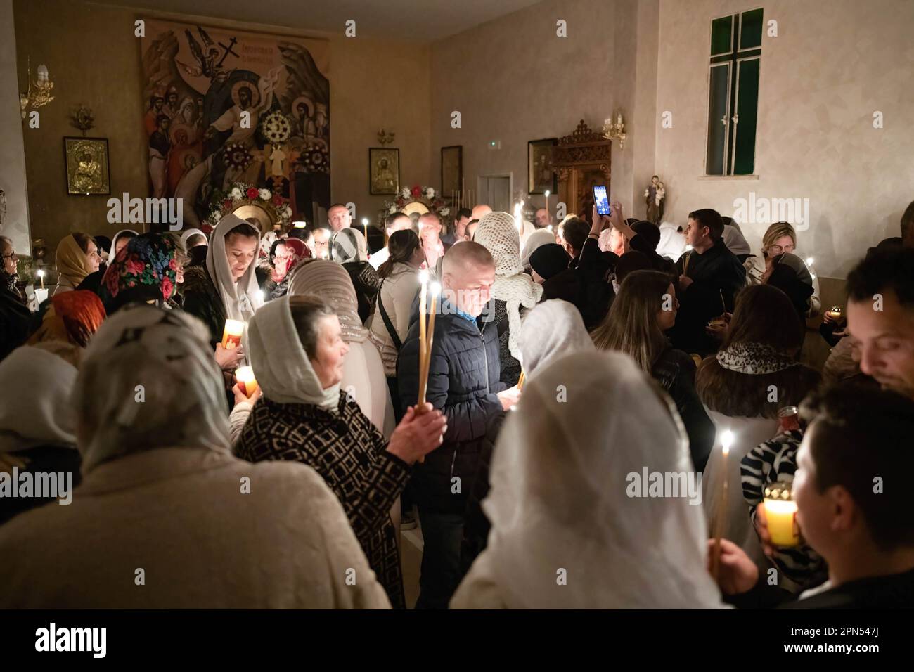 Das Heilige Feuer breitet sich unter den Gläubigen aus. Die Gläubigen der Gemeinde der Verkündigung, die Kirche, die von Rumänen des orthodoxen Glaubens von Ostia Lido besucht wird, nehmen am Ritual des Heiligen Feuers Teil. Der Ritus des Heiligen Feuers, am heiligen Samstag der Kirchen, die dem julianischen Kalender folgen, auf der Höhe des Ostertriduums für die orthodoxen Gläubigen aus der ganzen Welt, Findet seit mindestens sechs Jahrhunderten auf die gleiche Weise statt und stammt aus der Konstantinskirche im 4. Jahrhundert. Es ist die Andeutung der Flamme, die aus Christi leerem Grab fließt Stockfoto