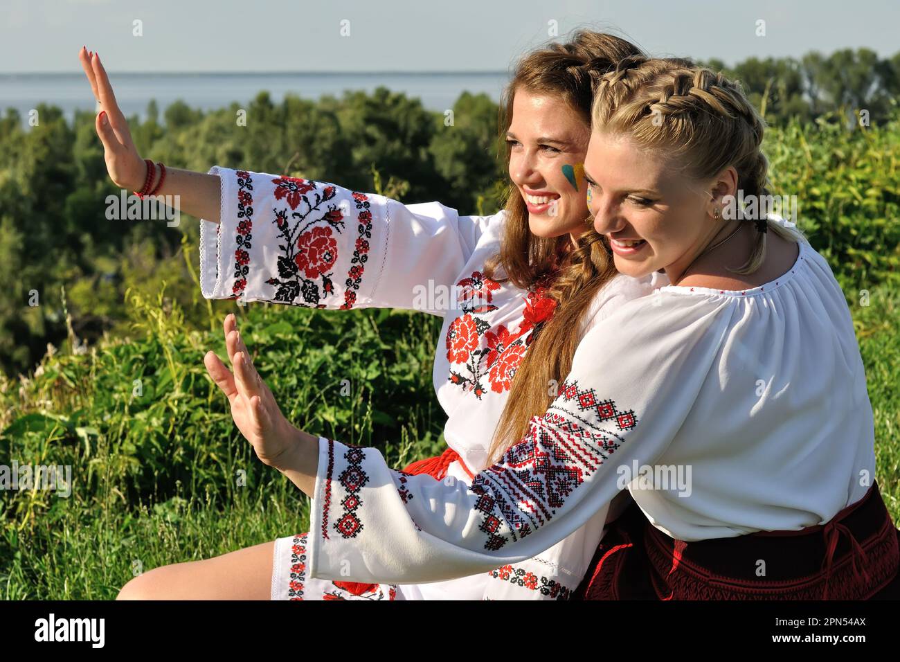 Außenporträt von zwei jungen ukrainischen Frauen in traditioneller ukrainischer Kleidung Stockfoto