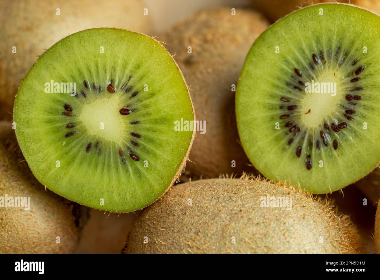 Eine Gruppe geschnittener grüner Kiwifrüchte mit schwarzen Samen, Details von in Stücke geschnittenem grünem Kiwipulp Stockfoto