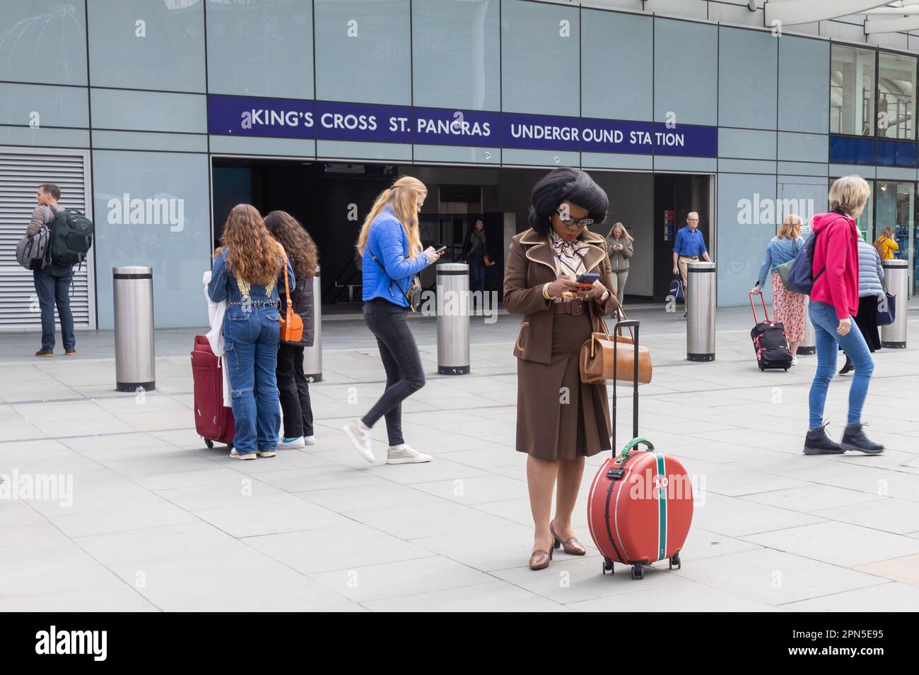 London UK - April 15 2023: Ein Mädchen in Form einer Stewardess im Stil der fünfziger Jahre, mit einer herrlichen Frisur auf dem Kopf, blickt in den ph-wert Stockfoto