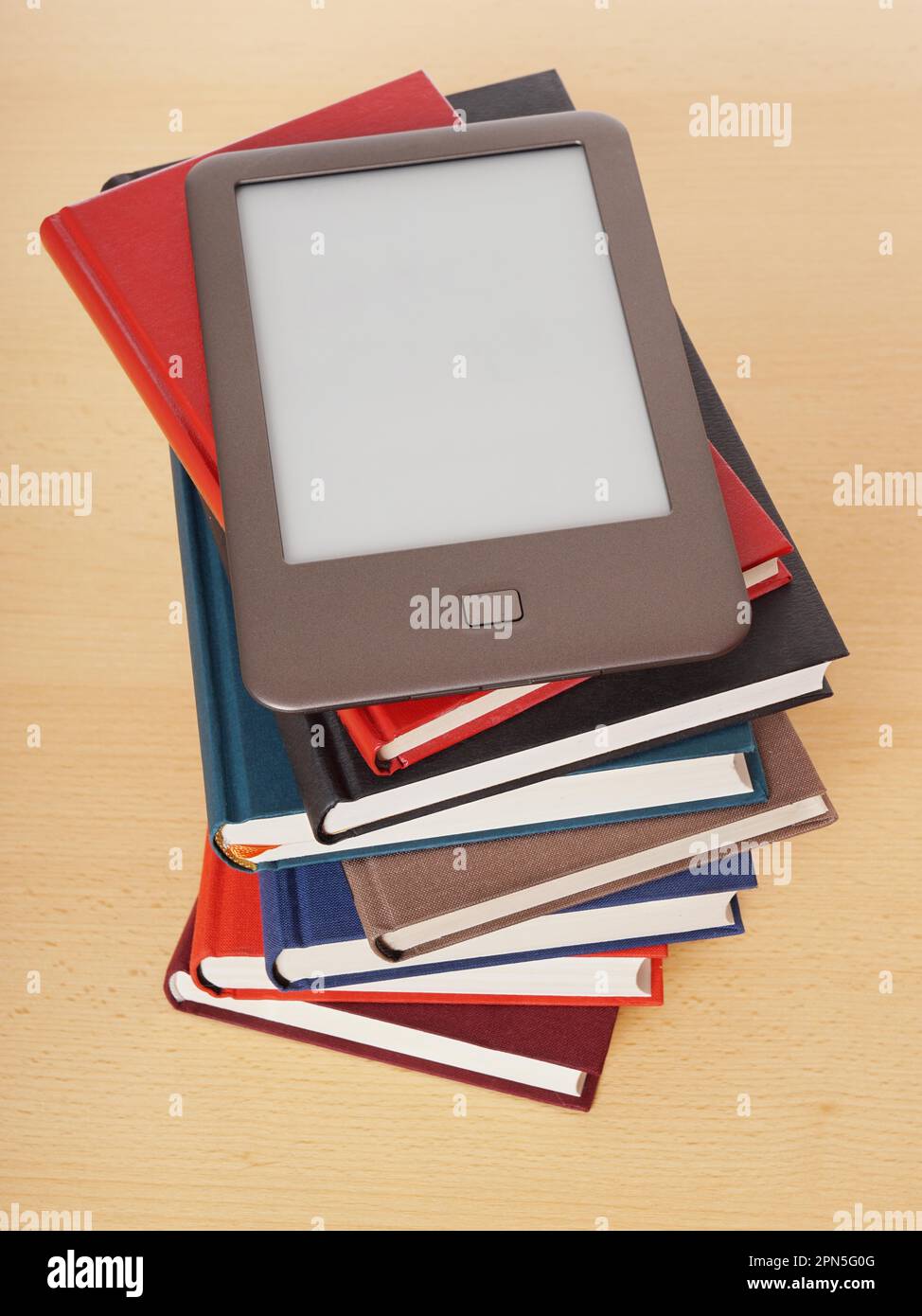 E-Book Reader oder E-Reader, der auf einem Stapel von Hardcover-Büchern liegt Stockfoto