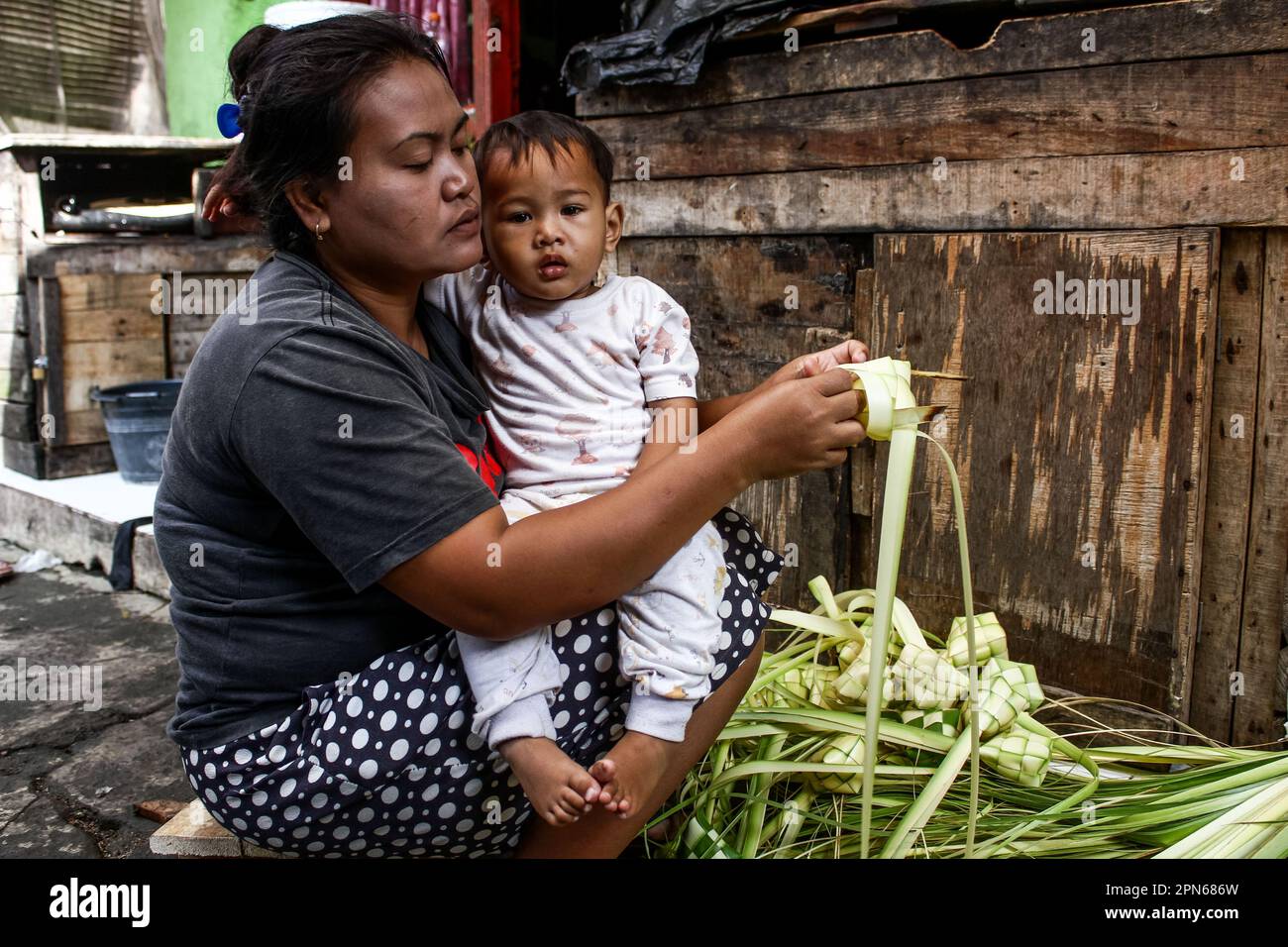 Bandung, West Java, Indonesien. 17. April 2023. Eine Frau webt Ketupat zur Vorbereitung der Eid al-Fitr-Feierlichkeiten in Bandung, Indonesien. Moslems auf der ganzen Welt werden in ein paar Tagen Eid al-Fitr feiern, da die Nachfrage nach Ketupat gestiegen ist. In der Tradition des indonesischen Volkes ist Ketupat eines der Speisen, die während des Eid serviert werden. Ketupat ist ein Reisgericht, das in einem rautenförmigen Bündel aus Kokosnusskohle gekocht wird. Ketupat hat einen sehr feinen Geschmack und wird in der Regel zusammen mit anderen Gerichten wie Rendang, einem getrockneten Rindercurry, serviert. (Kreditbild: © Algi Febri Sugita/ZUMA Press Wire) REDAKTIONELLE VERWENDUNG Stockfoto