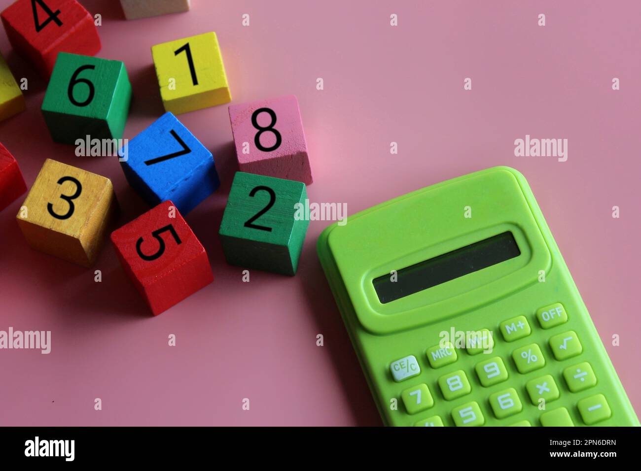 Taschenrechner und Holzwürfel mit mathematischem Symbol. Bildung und mathematisches Konzept Stockfoto