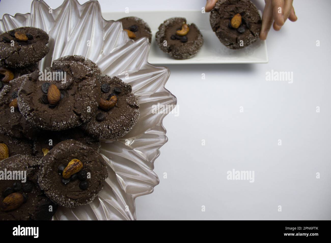 Handgemachter Kuchen mit Kakao, im Teller enthalten, von Hand genommen. Auf weißem Hintergrund. Stockfoto