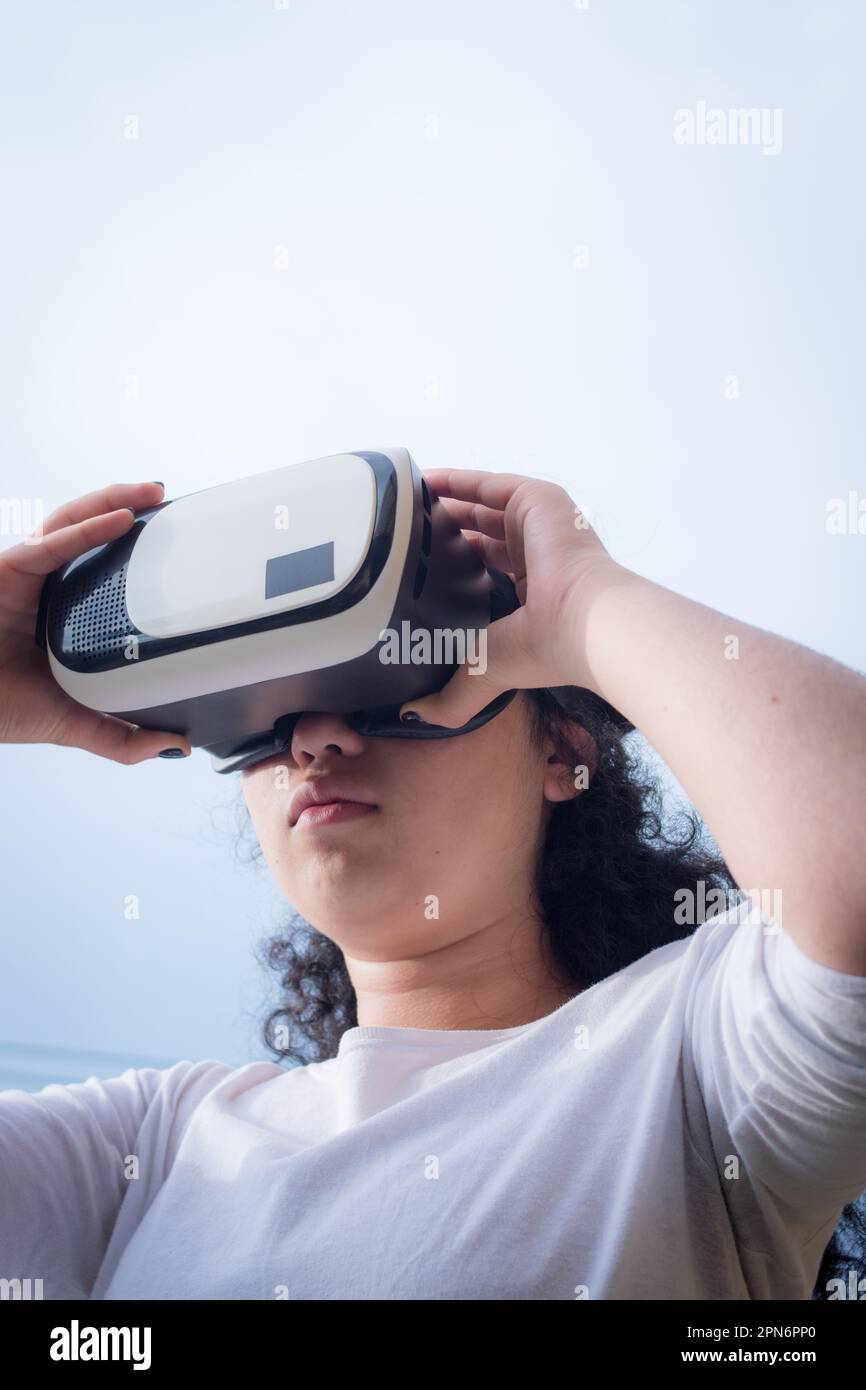 Junge Frau trägt eine Virtual-Reality-Maske an einem bewölkten Tag Stockfoto
