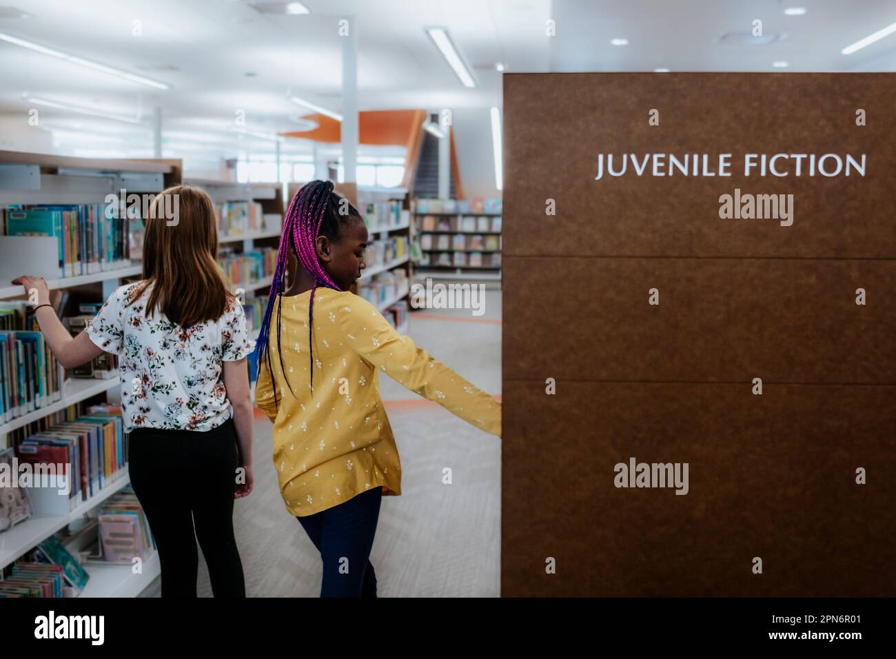 Zwei Mädchen im Grundalter erkunden die öffentliche Bibliothek Stockfoto