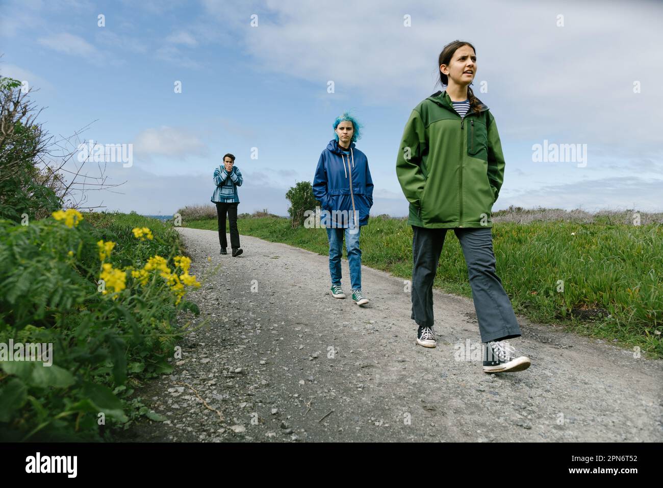 Teenager Girl läuft vor Geschwistern auf Einem Trail von der Küste Stockfoto