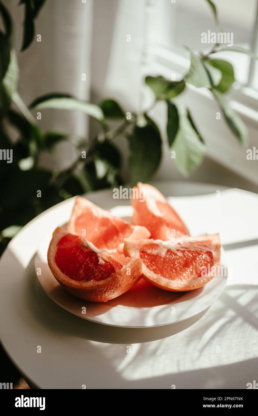 Lifestyle-Foto einer gesunden frischen Grapefruitscheibe im Sonnenlicht Stockfoto