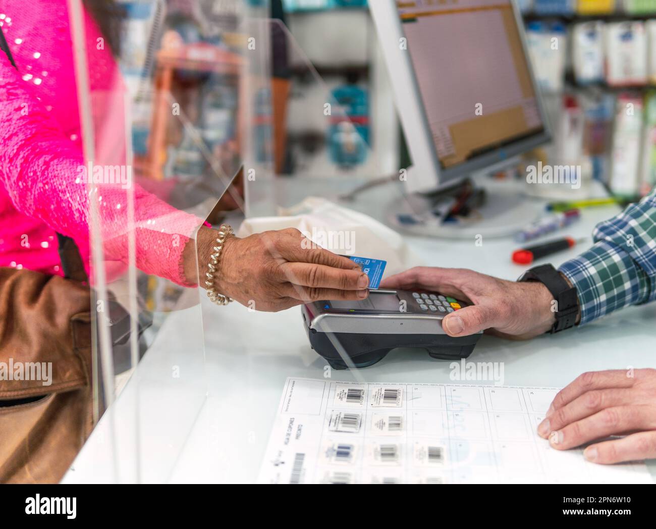 Frau, die in einer Apotheke für Produkte und Medikamente bezahlt Stockfoto