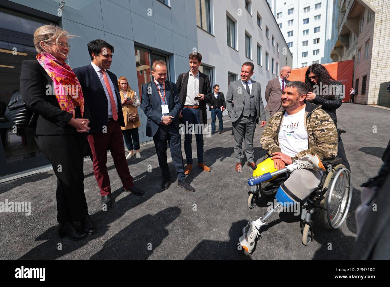 LEMBERG, UKRAINE - 14. APRIL 2023 - ausländische Gäste und Sponsoren sprechen mit einem Mann mit Beinprothesen an der Superhumans Prothetik and Rehabilitation medi Stockfoto