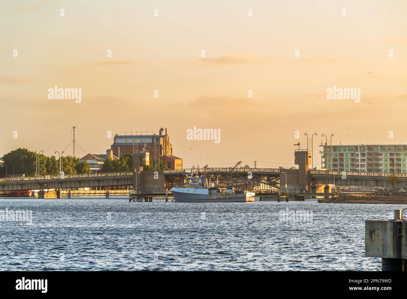 Industriegebiet von Port Adelaide mit einem Fischboot und der Birkenhead Bridge über den Port River bei Sonnenuntergang, Südaustralien Stockfoto