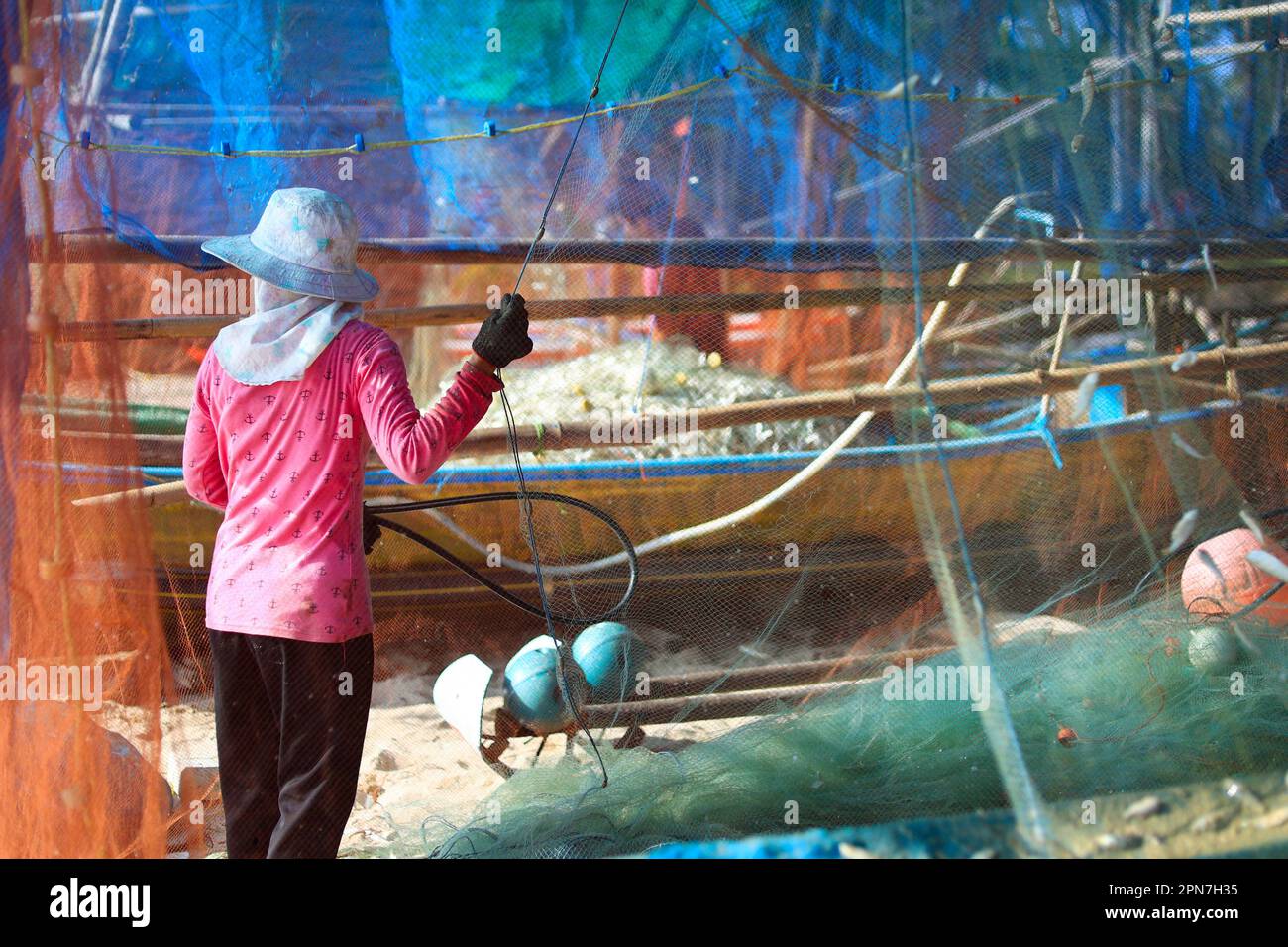 Frau, die Fischernetze reinigt, nachdem sie vom Fischen in der Provinz Phatthalung-Thailand zurückgekommen ist Stockfoto