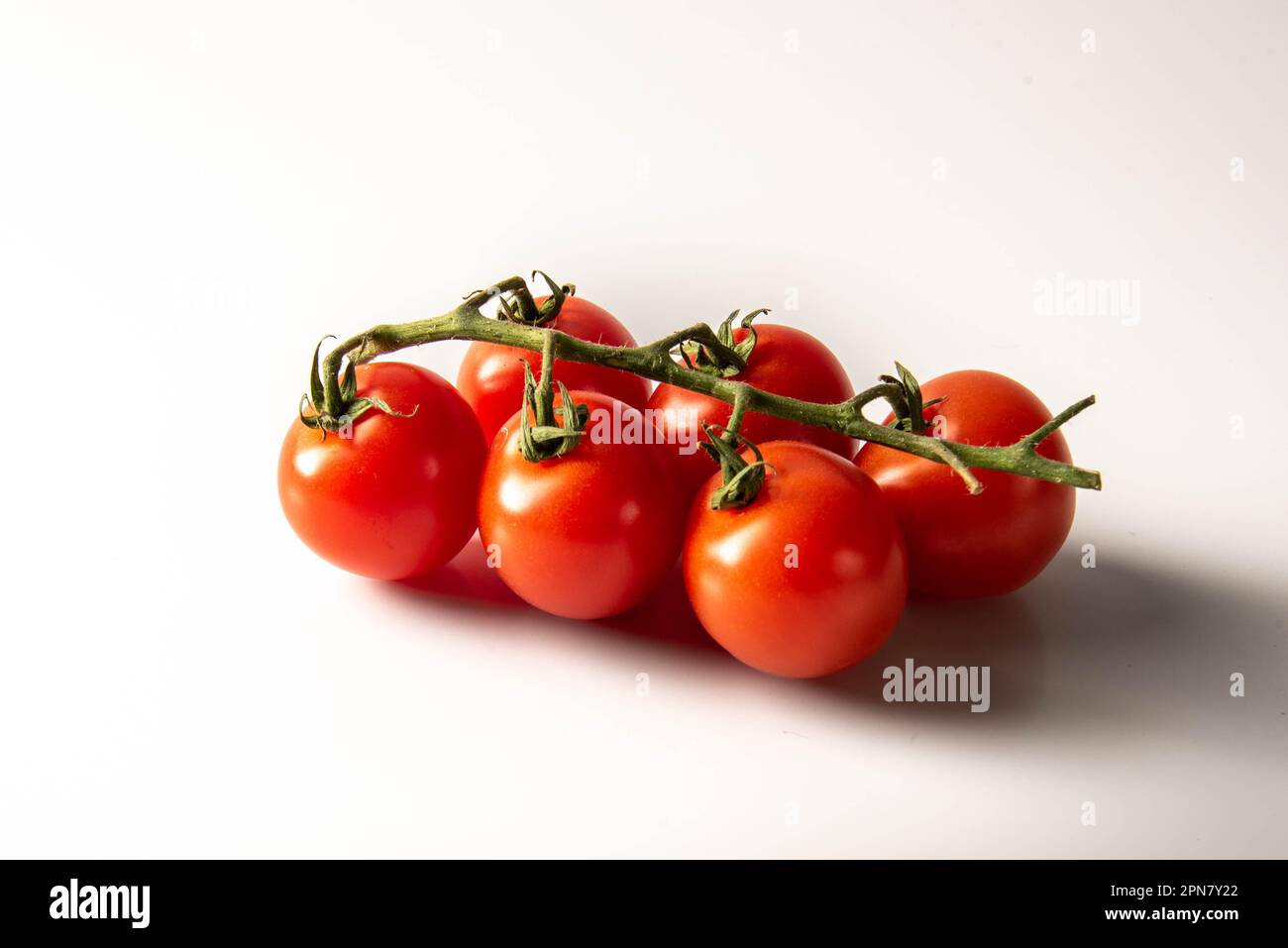 Frische rote Tomaten mit grünen Stielen, isoliert auf weißem Hintergrund. Stockfoto