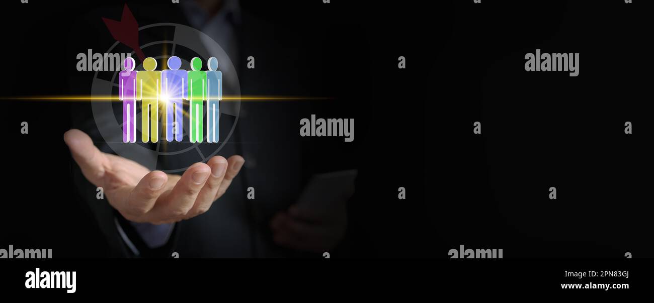 Maximieren Sie Ihr Unternehmenspotenzial mit Expert Human Resource Management: Die Hand eines Geschäftsmanns zielt auf die Symbole des Personals auf einer Dartscheibe Stockfoto