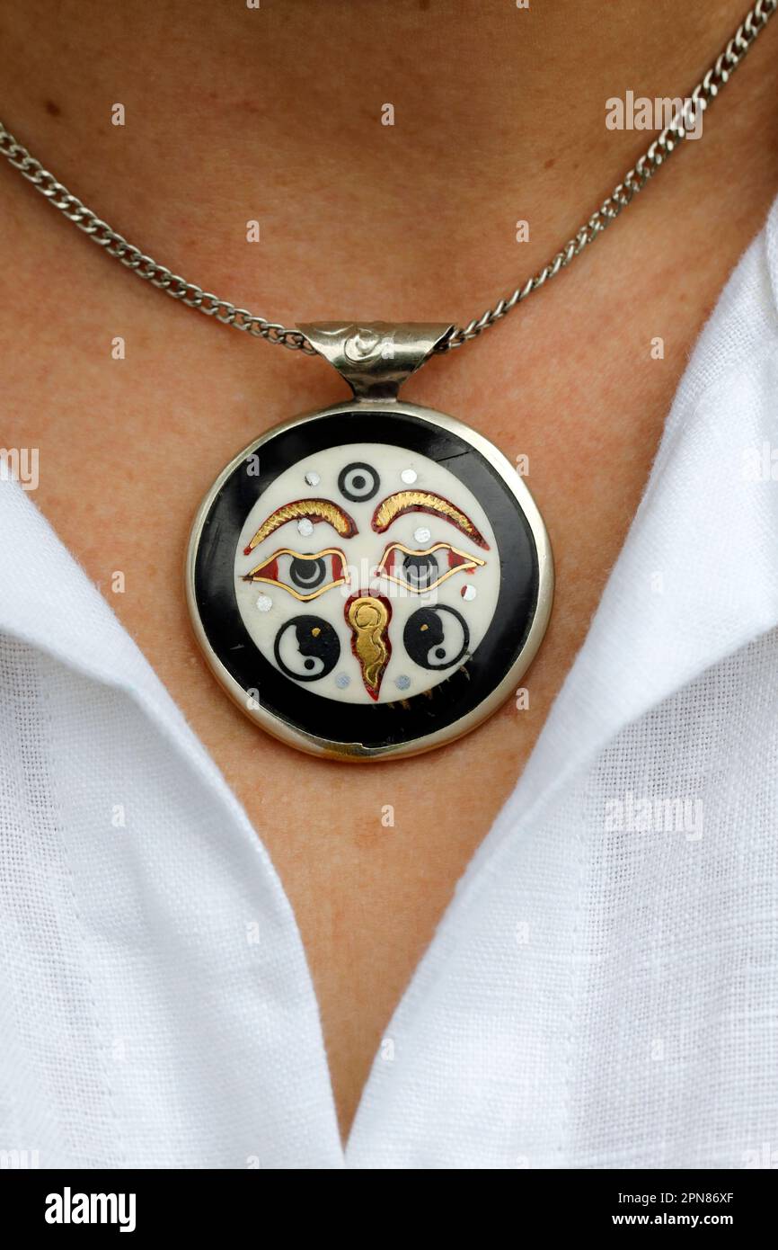 Frau mit tibetischem Messing und silbernem Auge des buddha-Mantra-Anhängers. Symbol des Buddhismus. Stockfoto