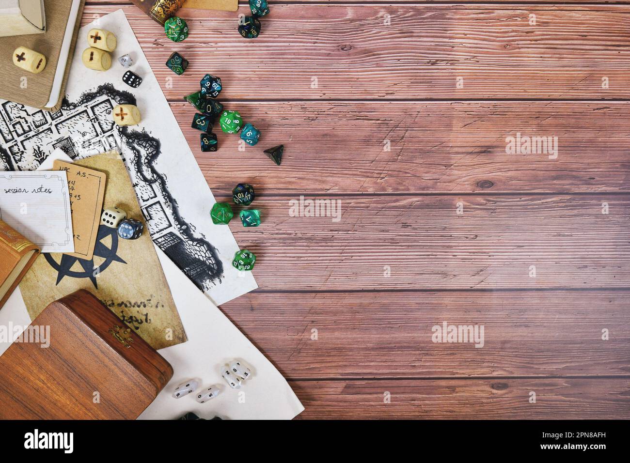 Tischrollenspiel flach liegender Hintergrund mit bunten Rollenwürfeln, Regelbüchern und Notizen auf Holzhintergrund mit Platz zum Kopieren Stockfoto