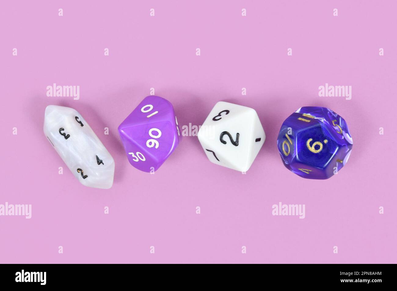 Verschiedene Rollenspiel-RPG-Würfel auf violettem Hintergrund Stockfoto
