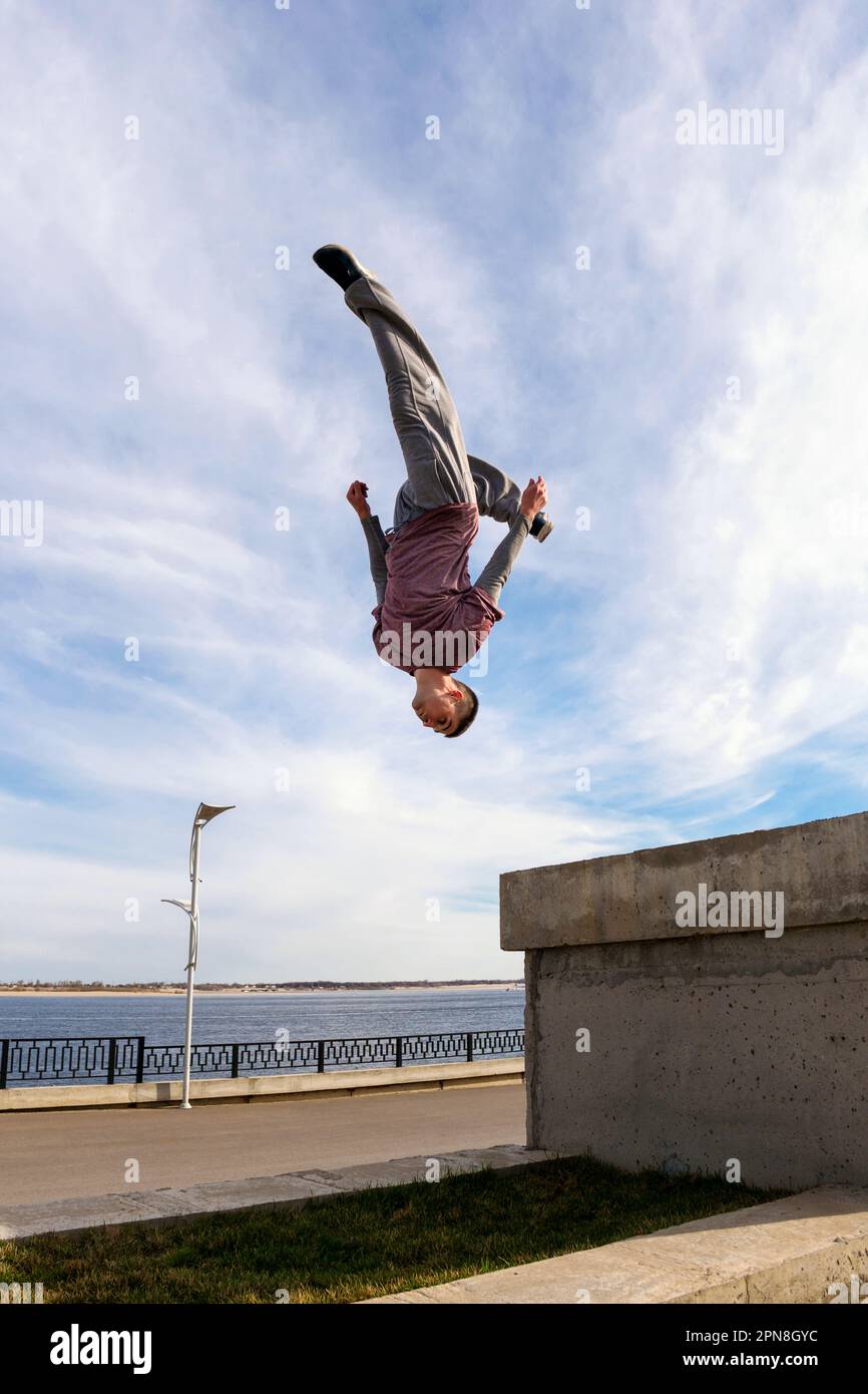 Ein Mann, der einen Salto macht. Parkour-Sportler-Training in Sportkleidung in der Stadt. Free Runner Jumping haben ein Workout. Aktiver Lifestyle. Extremsport, o Stockfoto