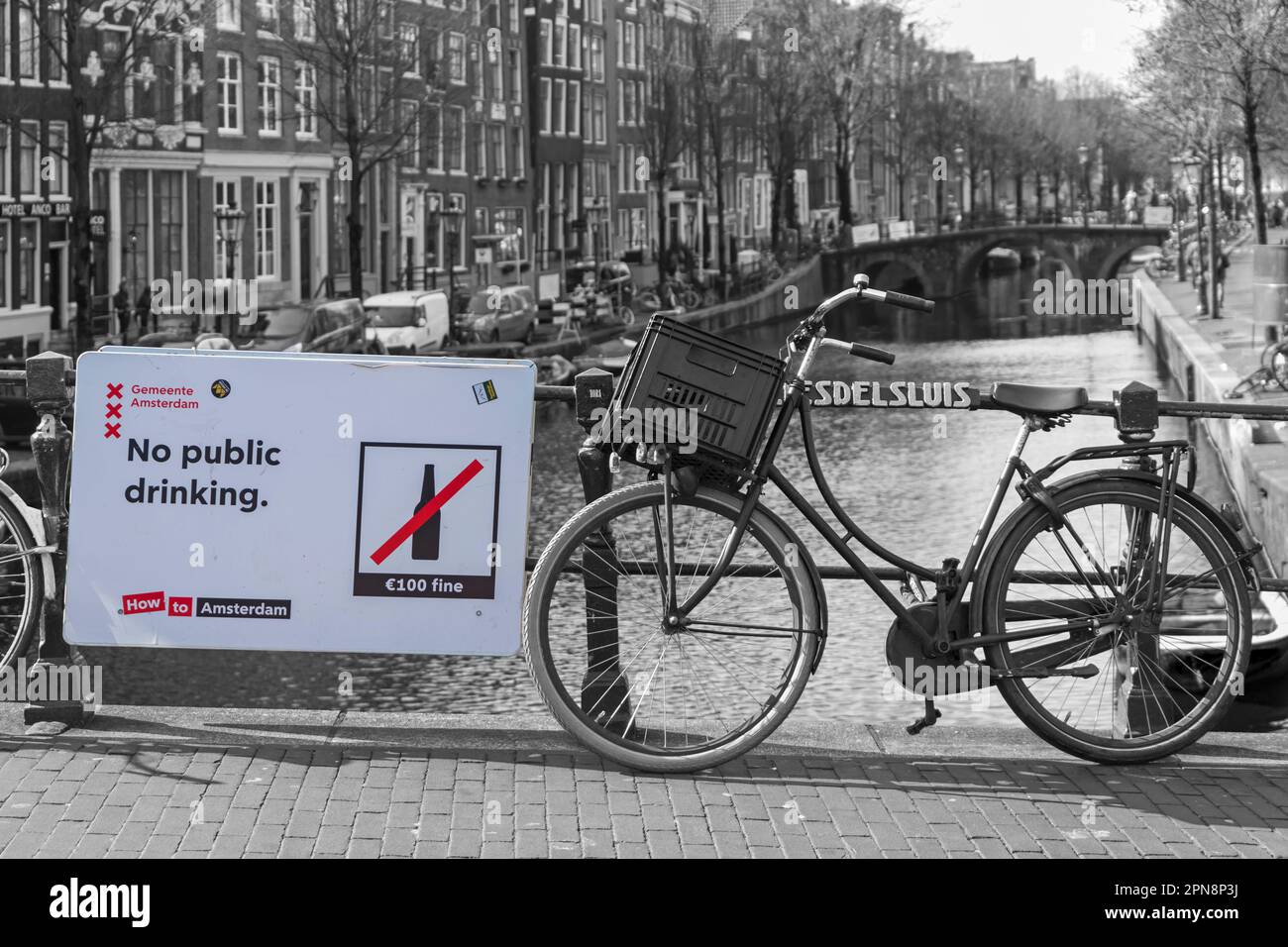 Kein öffentliches Trinken 100 Euro feines Schild auf der Brücke über den Kanal in Amsterdam, Holland, Niederlande im April - selektive Farbgebung, Farbpracht Stockfoto