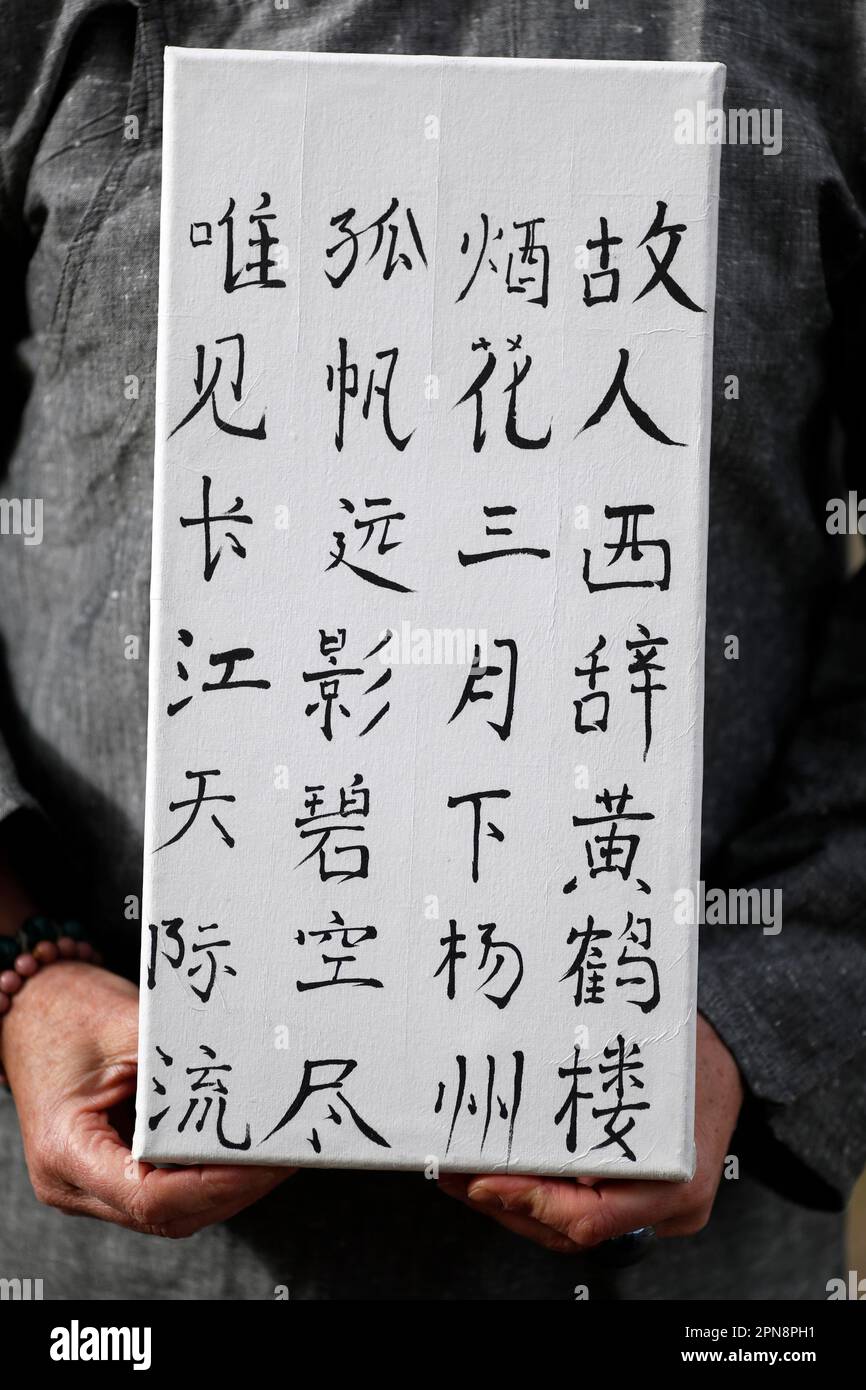 Eine Frau, die ihre Arbeit mit chinesischen Figuren zeigt. Chinesische Kalligraphie. Frankreich. Stockfoto