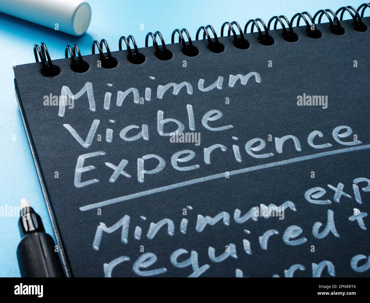 Seite des Notizblocks mit dem Zeichen „Minimum Viable Experience MVE“. Stockfoto