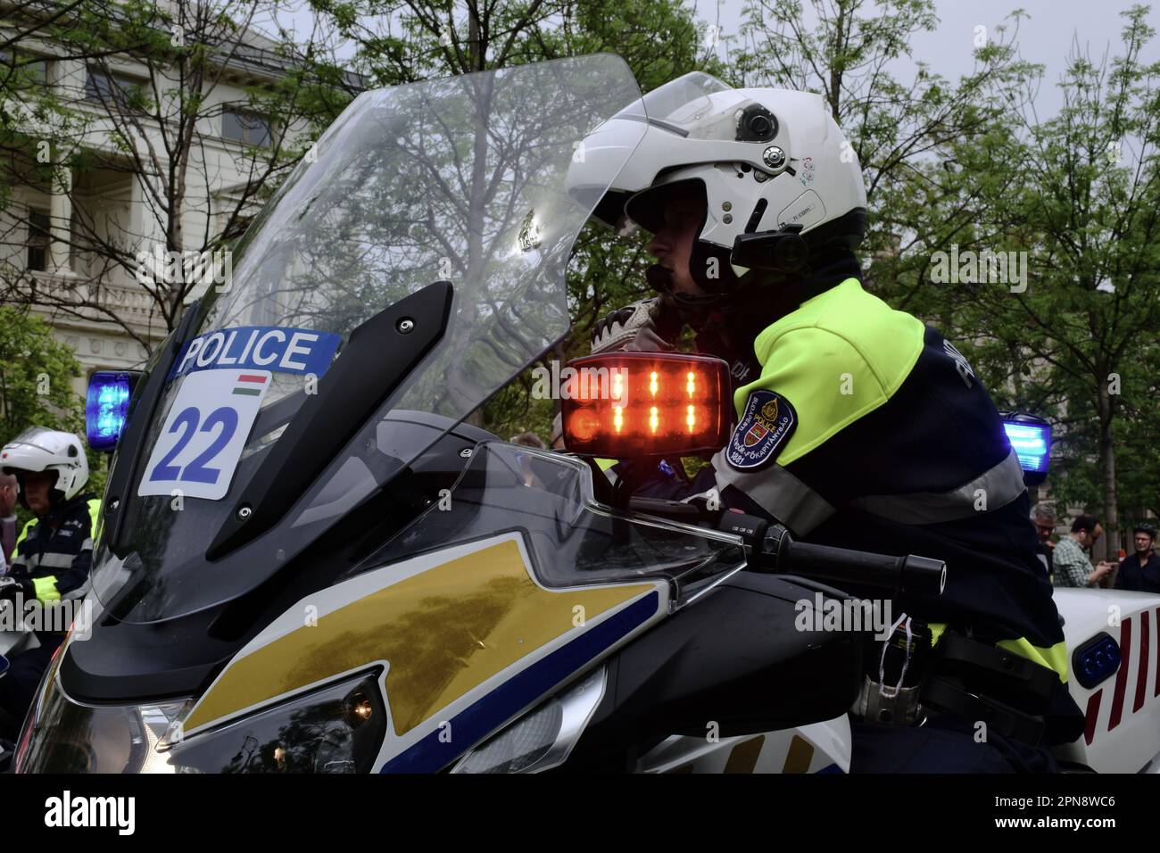 Polizist auf einem großen BMW-Motorrad, führend beim Giro-Fahrrad-Straßenrennen in Budapest im Mai 2022. Weißer Helm. Blinkende rote Warnblinkleuchte. Stockfoto