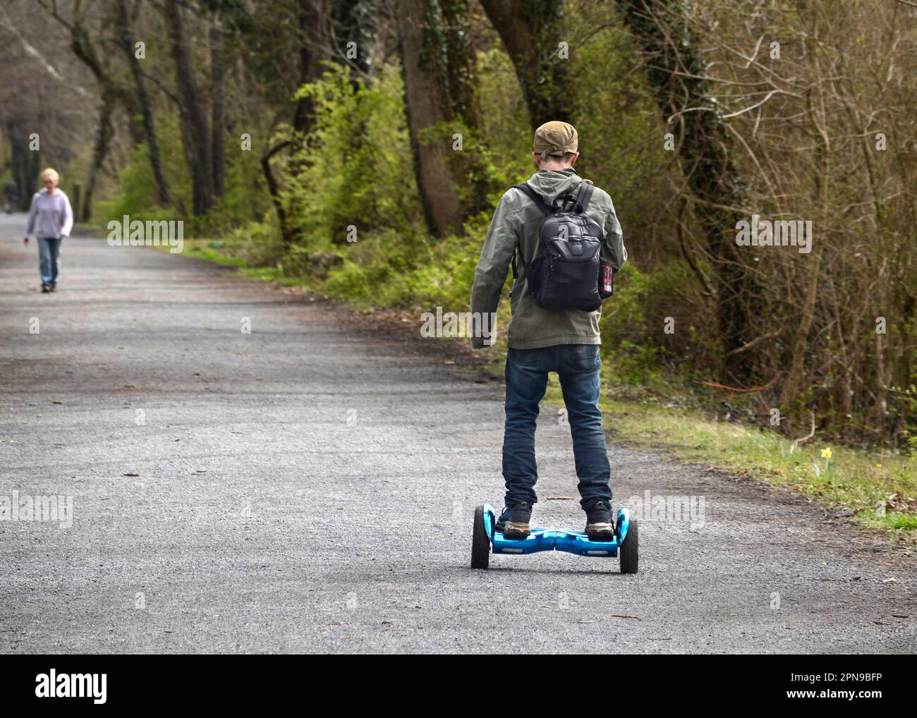 Ein junger Mann fährt mit seinem Hooverboard auf dem öffentlichen Virgiia Creeper Wander-, Fahrrad- und Joggingpfad in Abingdon, Virginia. Stockfoto