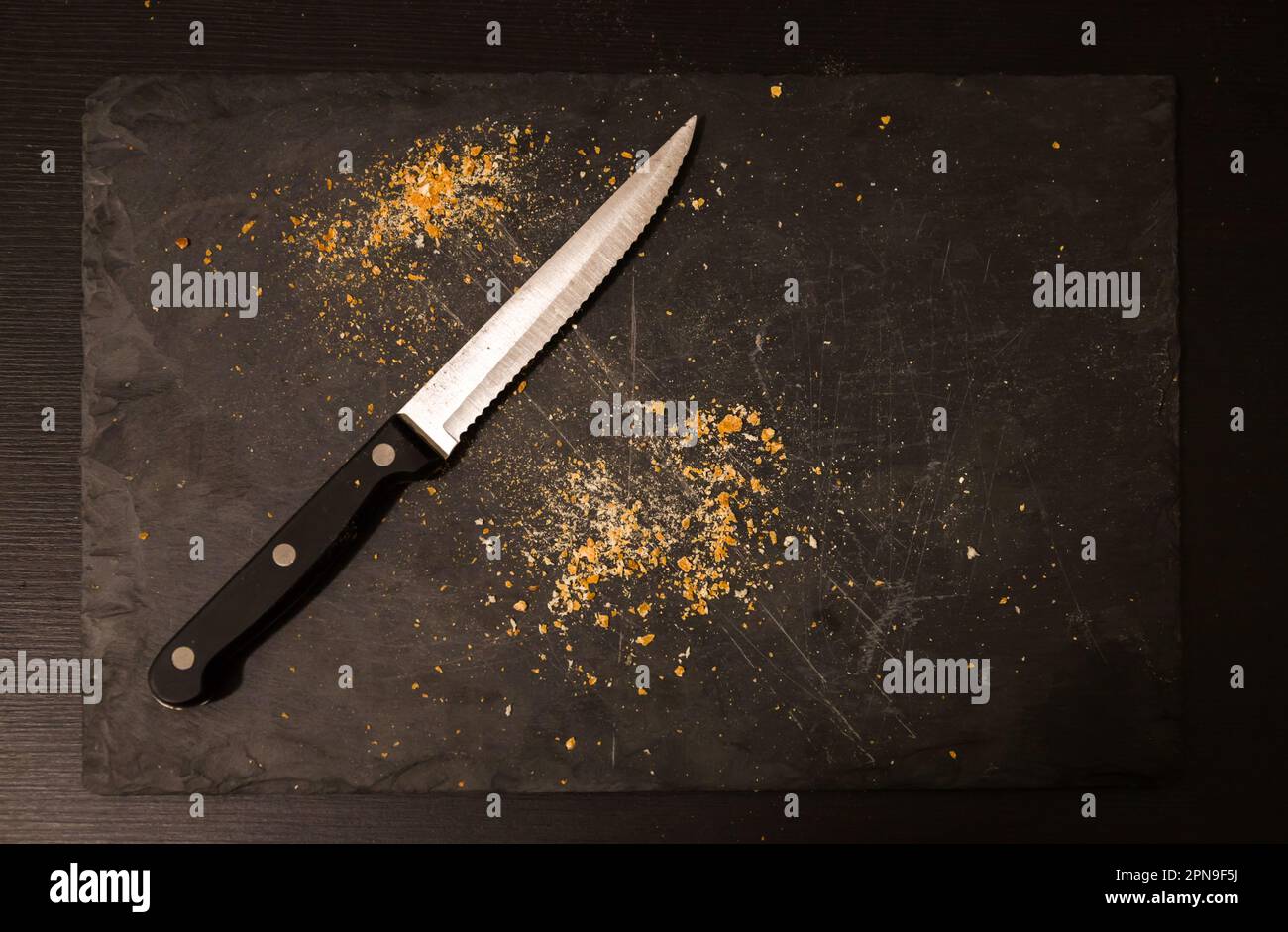 Leeres Brett mit Semmelbröseln und Messer. Essen und Besteck. Der Begriff des Hungers. Kein Essen. Nahrungsmittelkrise Stockfoto