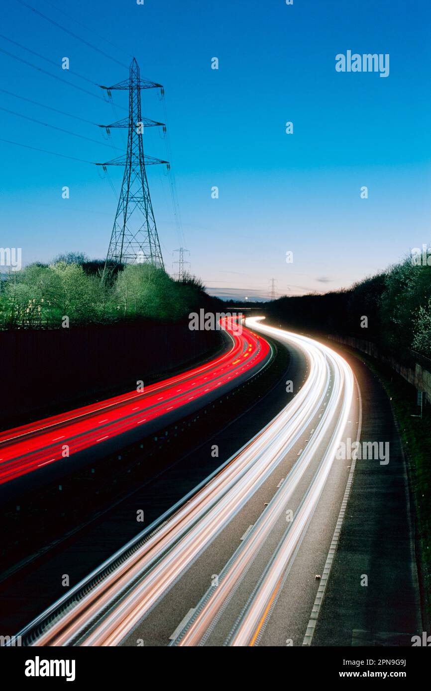 Autobahnfahrt - lange Lichtwege vom Verkehr in der Dämmerung. Konzepte von Pendeln, Reisen, Fahrzeugen, Bewegung. Autobahn M60, England, Großbritannien Stockfoto