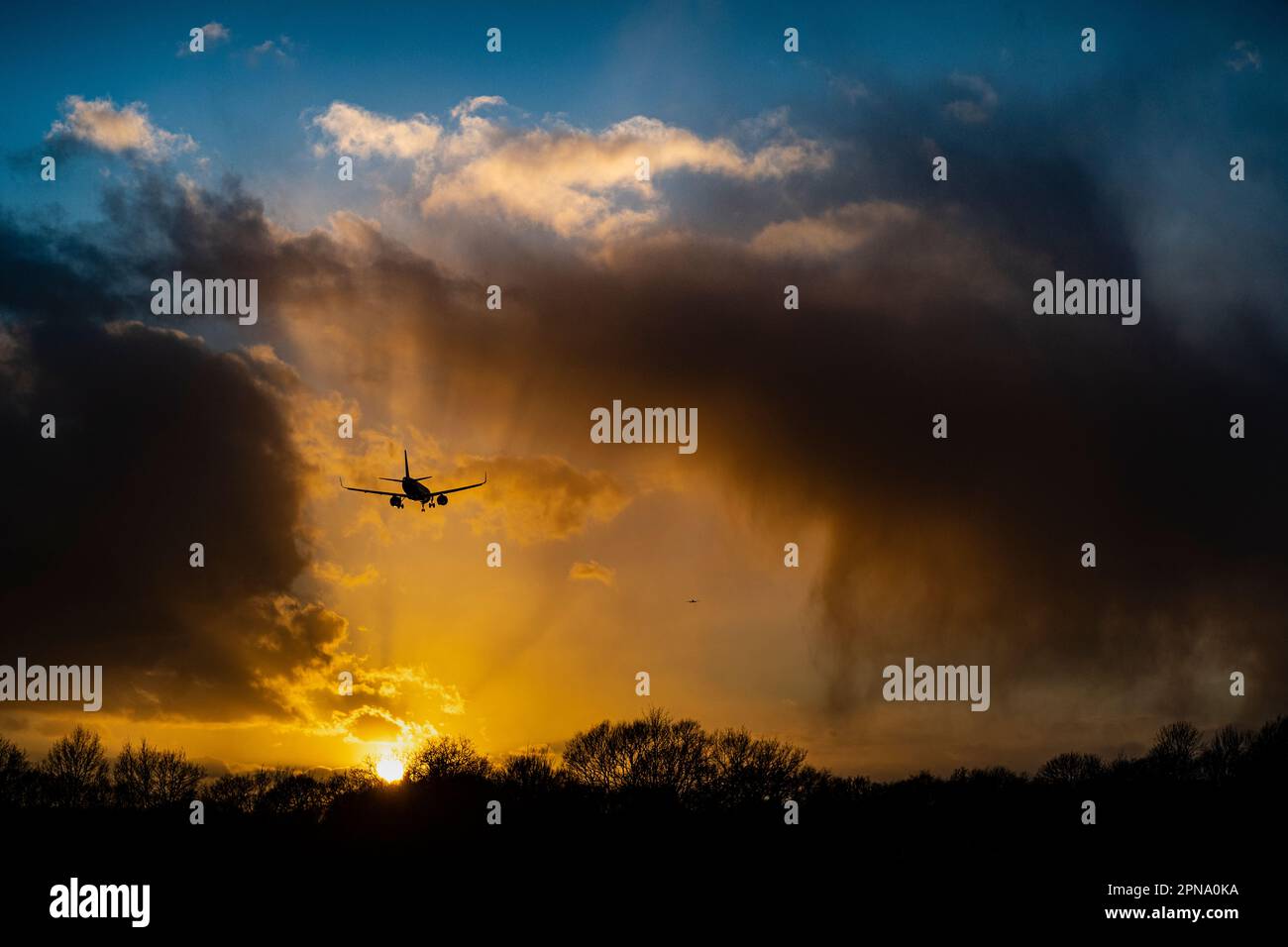 Flugzeuglandung, nachdem der Flughafen wegen starkem Wind, Rückstand von Flugzeugen, die auf die Landung warten, geschlossen wurde, atemberaubende Sonnenuntergänge am frühen Abend im Winter Stockfoto