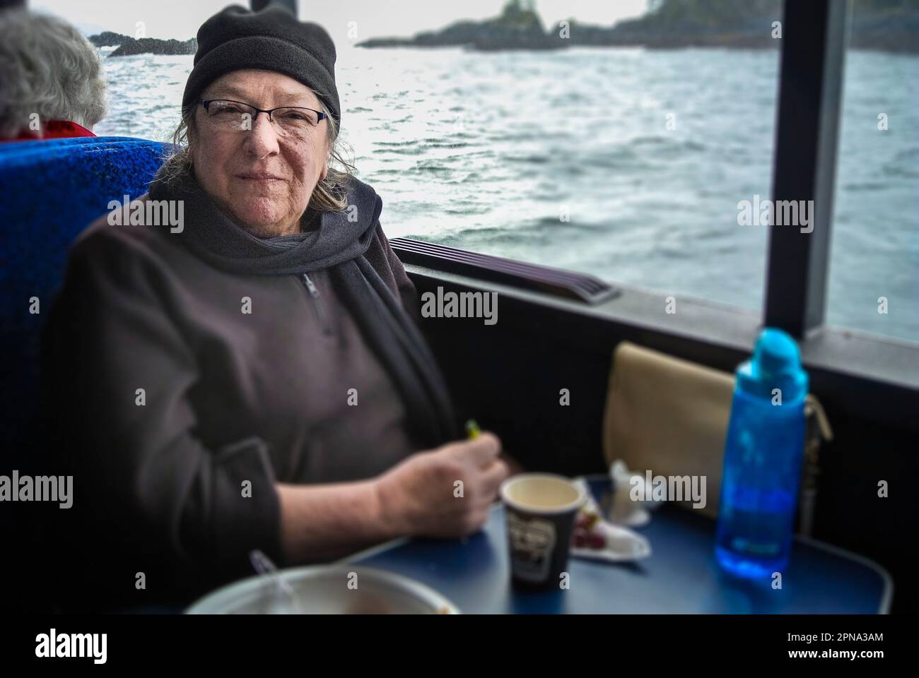 Eine Frau aus Alaska genießt eine Bootsfahrt mit Wildtier- und Walbeobachtung in Sitka, Alaska, USA. Stockfoto