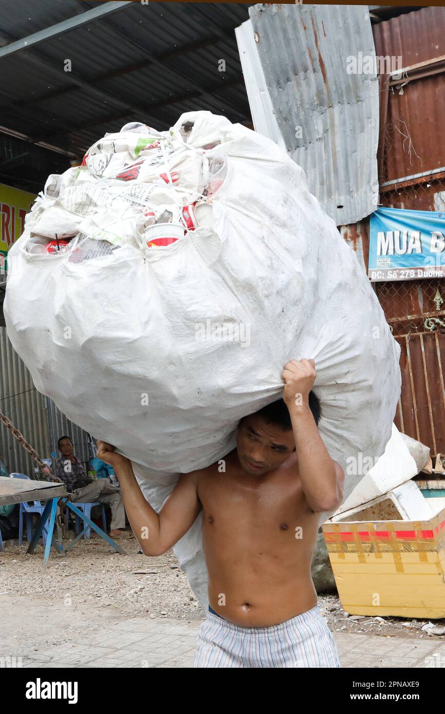 Recycelten Müll sammeln. Mann mit einer schweren Tasche auf den Schultern. Chau Doc. Vietnam. Stockfoto