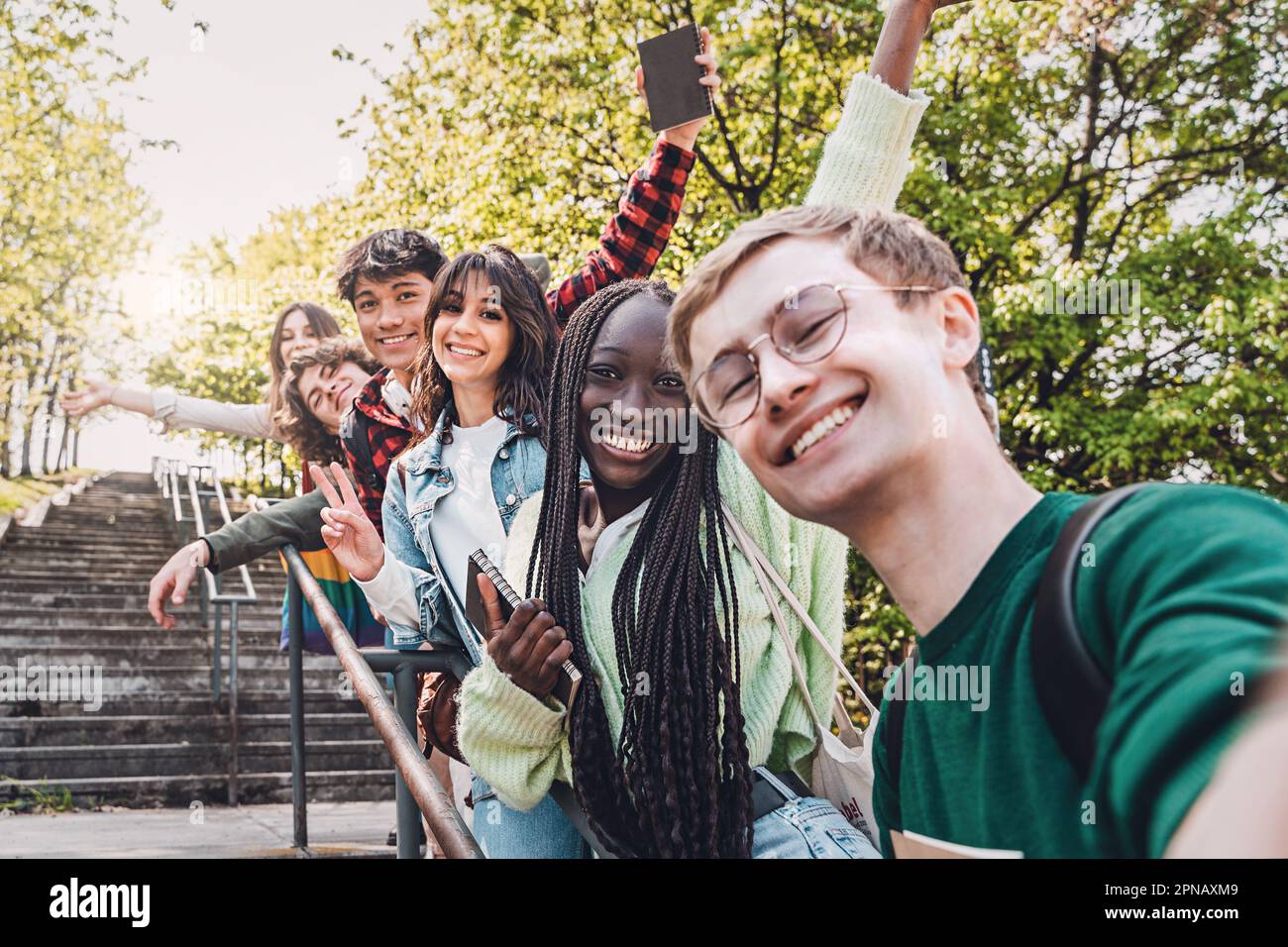 Eine vielfältige Gruppe von Freunden der Generation Z, darunter eine Engländerin, Italiener, eine Filipino und ein afrikanisches Mädchen mit Dreadlocks, die glücklich zusammen für ein Selfie posieren Stockfoto
