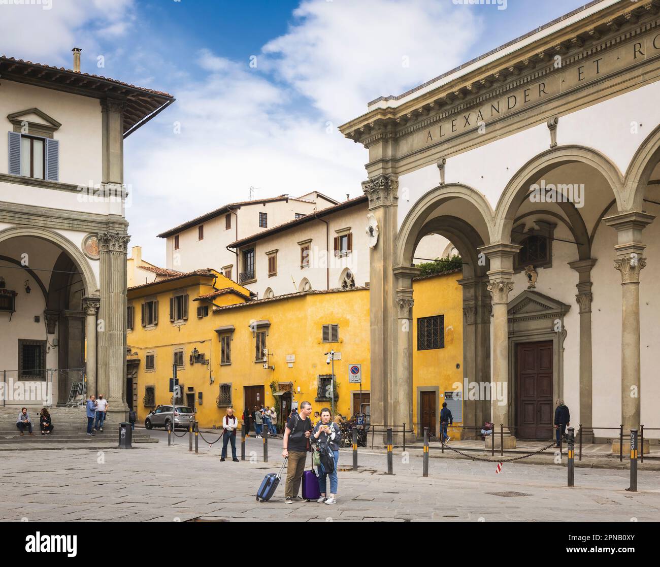 Zwei Besucher überprüfen ihren Aufenthaltsort auf einem Smartphone auf der Piazza della Santissima Annunziata. Florenz, Toskana, Italien. Das historische Zentrum von FL Stockfoto